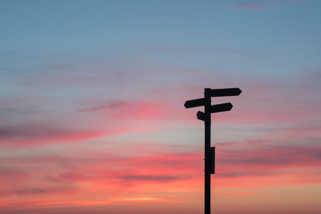 direction road sign with sunset in the background